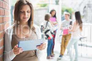 Pretty student smiling and holding tablet