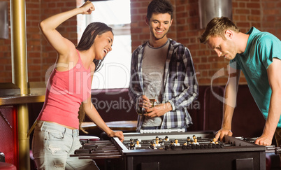 Happy friends playing table football