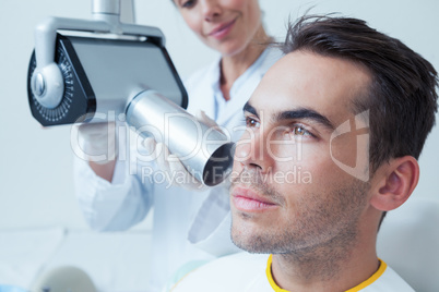 Serious young man undergoing dental checkup