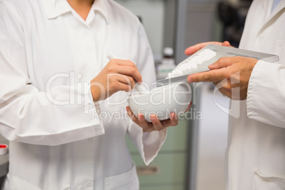 Junior pharmacist mixing a medicine with her senior