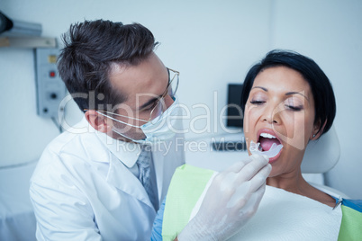 Male dentist examining womans teeth