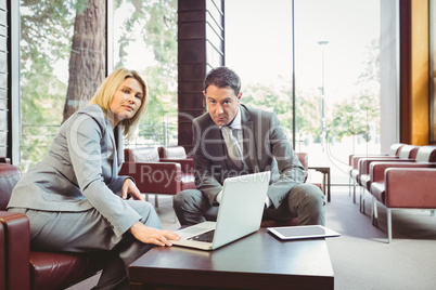 Focused business team having a meeting using laptop