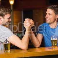Happy friend arm wrestling each other