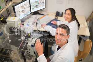 Biochemistry students using large microscope and computer