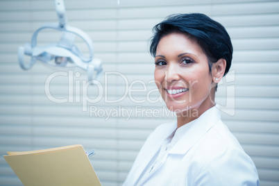 Smiling female dentist reading reports