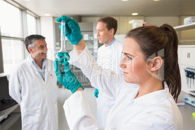 Young scientist holding up test tube