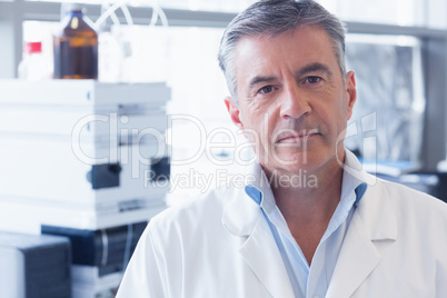 Portrait of an unsmiling scientist wearing lab coat