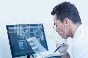 Male dentist looking at x-ray