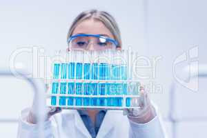 Science student holding tray of test tubes