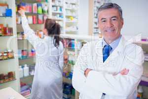 Pharmacist looking at camera with student behind him