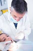 Dentist examining a patients with angled mirror