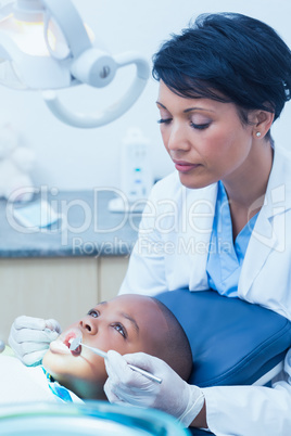 Female dentist examining boys teeth