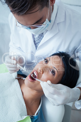 Male dentist examining womans teeth