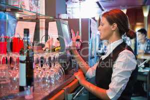 Happy barmaid using touchscreen till