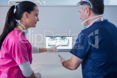 Dentist and assistant looking at x-ray together