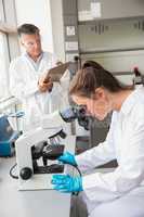 Young scientist looking through microscope