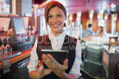 Focused barmaid using touchscreen till