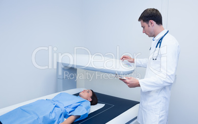 Doctor holding a radiography machine over a patient