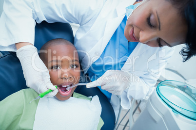 Female dentist examining boys teeth