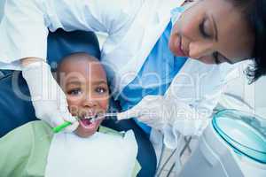 Female dentist examining boys teeth