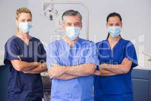 Co-workers wearing surgical mask with arms crossed