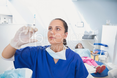 Pediatric dentist preparing an injection