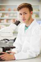 Young scientist working with microscope