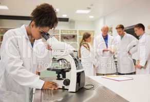 Happy medical student working with microscope