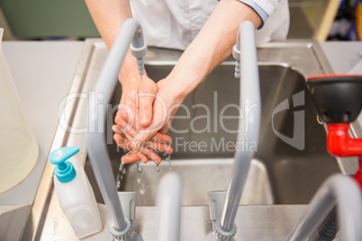 Pharmacist washing his hands at sink