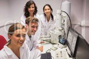 Biochemistry students using large microscope and computer