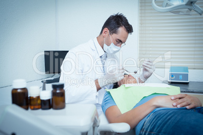 Male dentist examining womans teeth