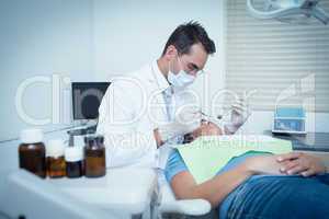 Male dentist examining womans teeth