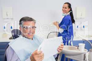 Smiling patient holding a mirror