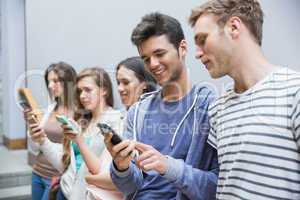 Students using their smartphones in a row