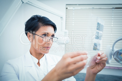 Female dentist looking at x-ray