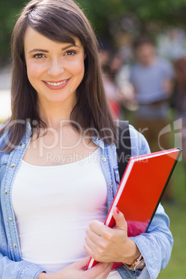 Pretty student smiling at camera outside on campus