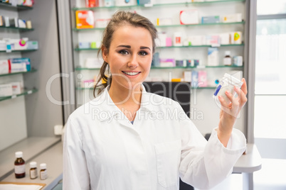 Junior pharmacist holding medicine jar