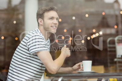 Smiling student sitting with a hot drink