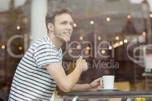 Smiling student sitting with a hot drink