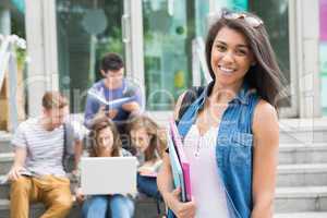 Pretty student smiling at camera outside