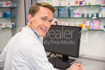 Happy pharmacist using the computer