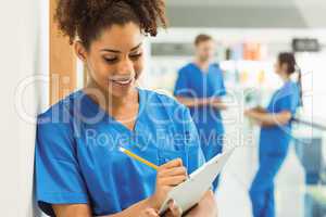 Medical student taking notes in hallway