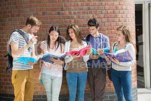Happy students standing and reading