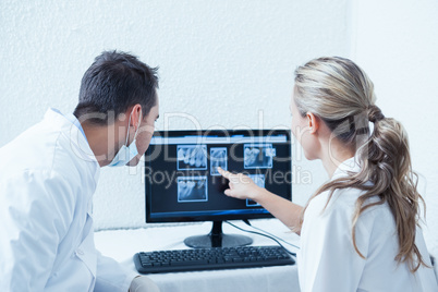 Dentists looking at x-ray on computer