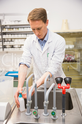 Handsome pharmacist washing his hands