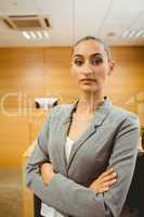 Unsmiling lawyer looking at camera crossed arms