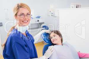Smiling pediatric dentist with a happy young patient