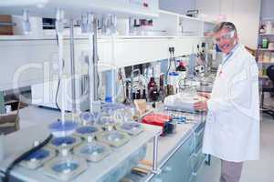 Scientist carrying out an experiment looking at the camera