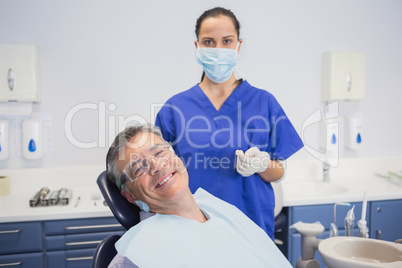 Dentist wearing surgical mask with a smiling patient