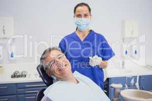 Dentist wearing surgical mask with a smiling patient